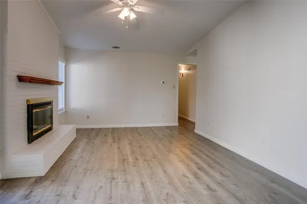 an empty room with wooden floor and fireplace
