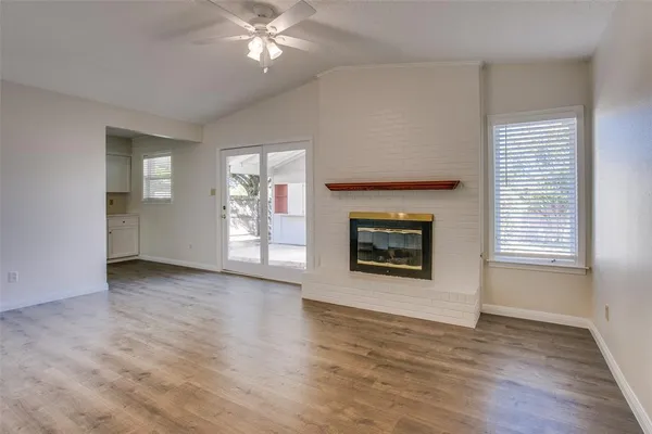 an empty room with windows and fireplace