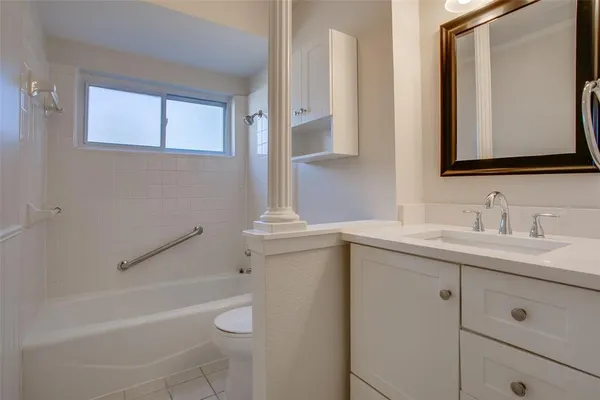 a bathroom with a granite countertop sink toilet and mirror