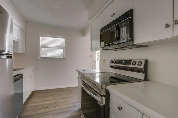 a kitchen with a stove microwave and sink