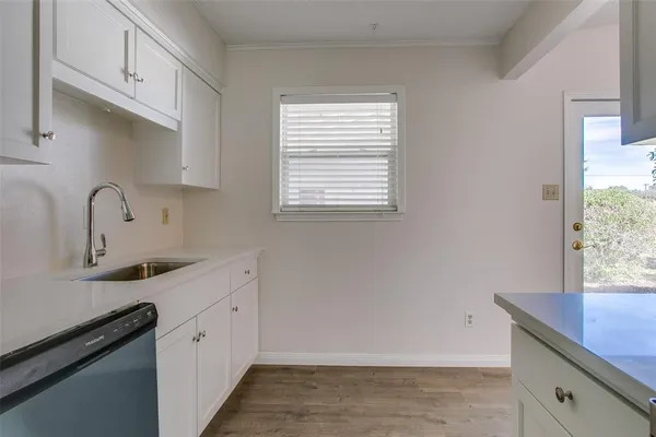 a kitchen with a sink cabinets and window