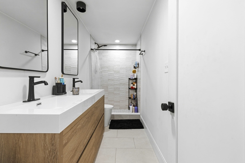 92 Chelsea Street, Unit 1 Boston, MA 02128 - Photo 6 of 14 a bathroom with a sink a mirror and shower