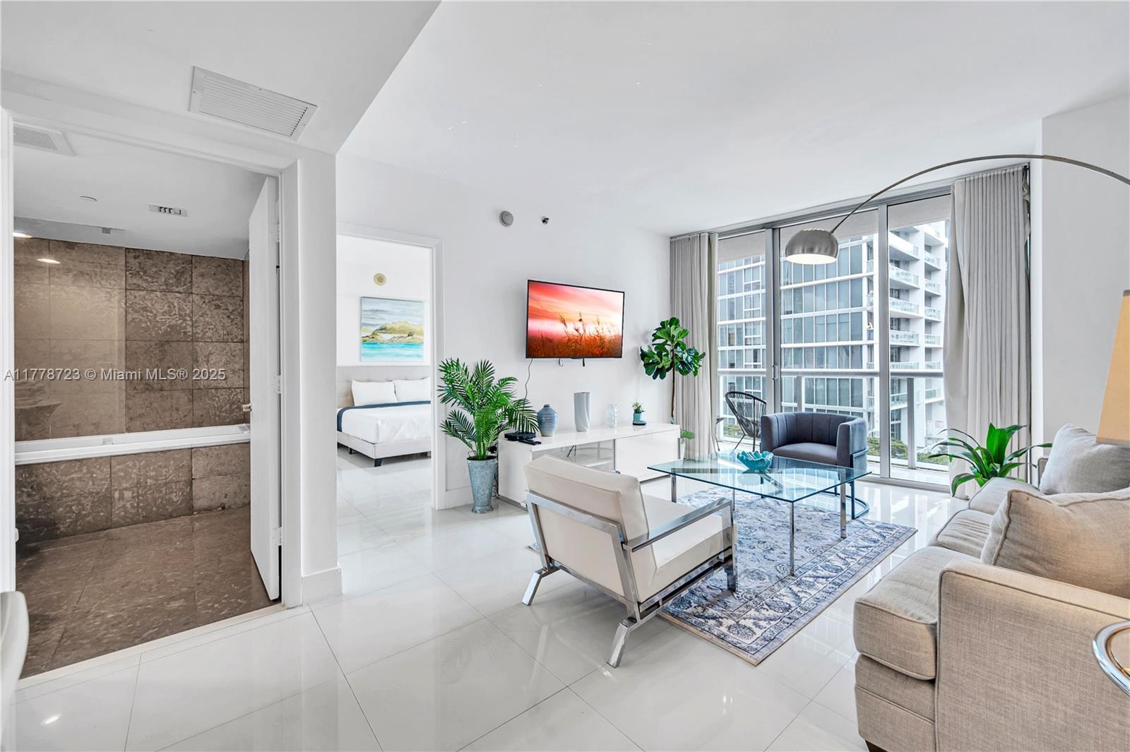 485 Brickell Avenue, Unit 1711 Miami, FL 33131 - Photo 2 of 15 a living room with furniture and a large window