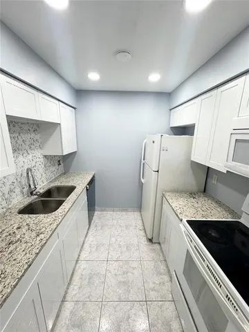 a kitchen with a sink stove and refrigerator