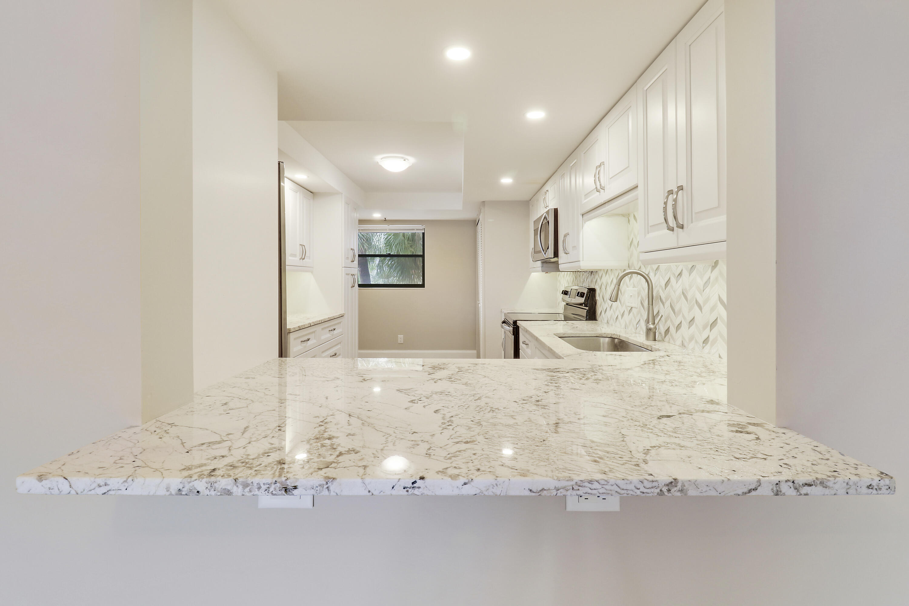 1036 Highway 1, Unit 321 North Palm Beach, FL 33408 - Photo 11 of 40 a large white bed in a white kitchen