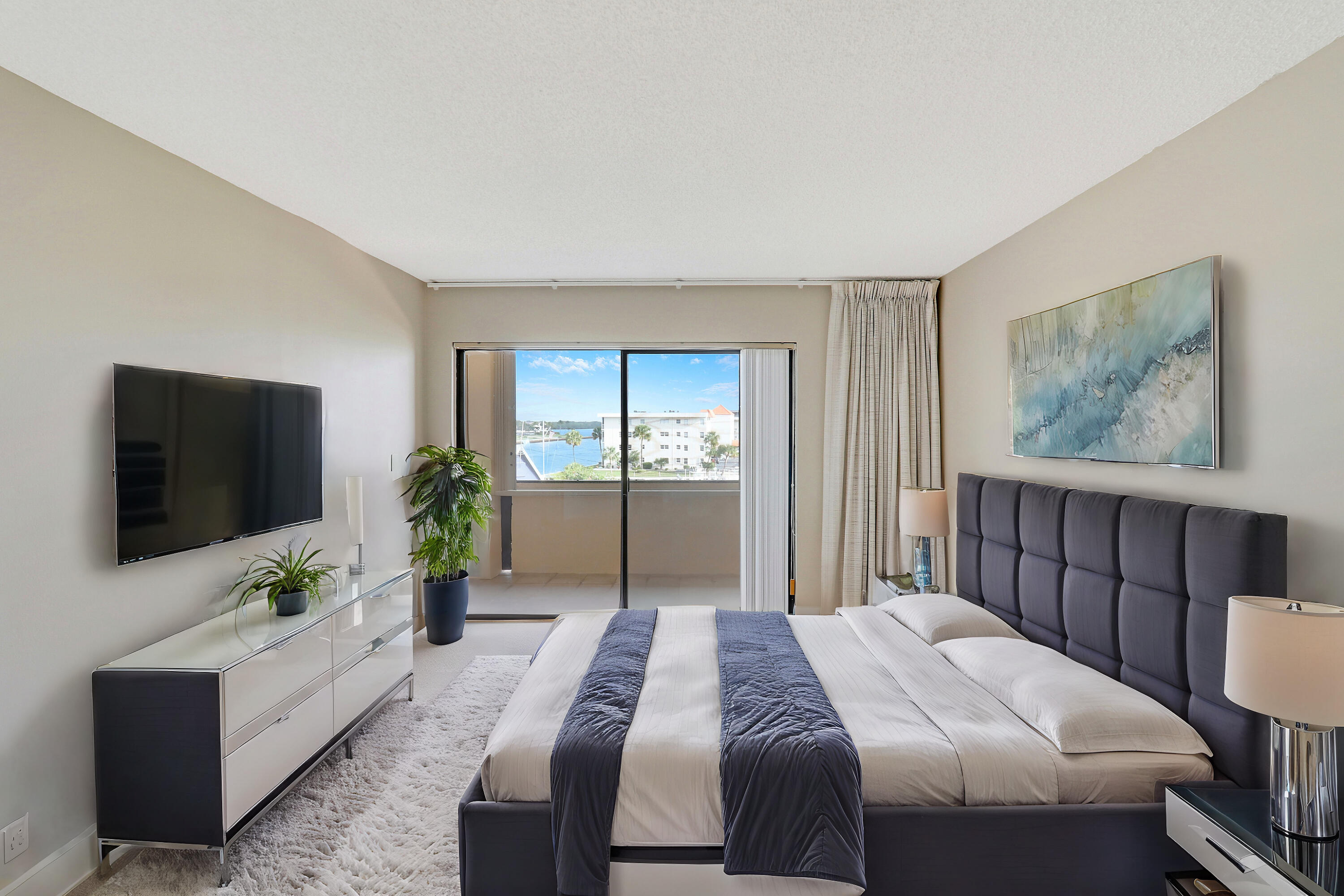 1036 Highway 1, Unit 321 North Palm Beach, FL 33408 - Photo 12 of 40 a bedroom with a large bed and a flat screen tv