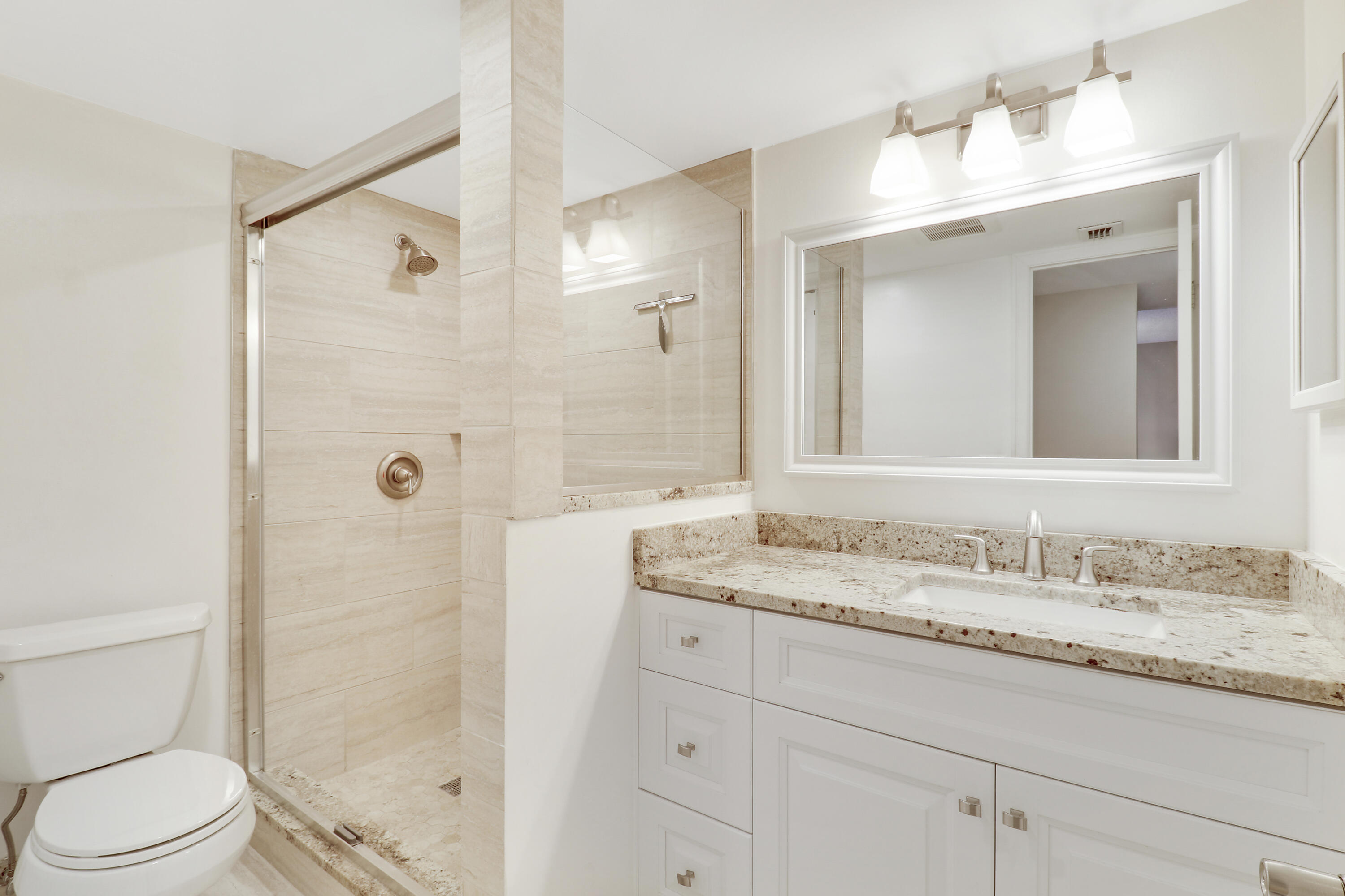 1036 Highway 1, Unit 321 North Palm Beach, FL 33408 - Photo 28 of 40 a bathroom with a granite countertop sink toilet a shower and a mirror