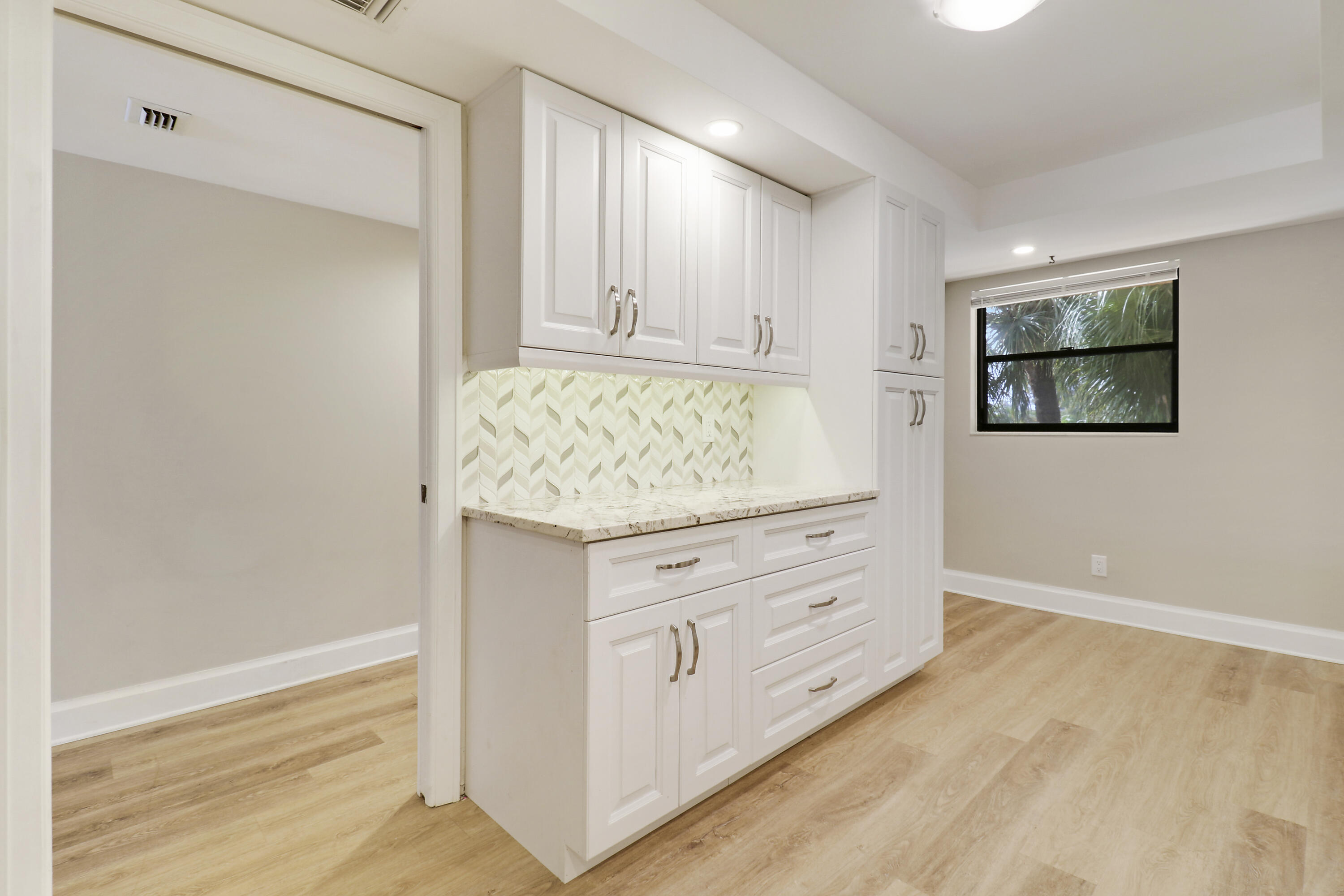 1036 Highway 1, Unit 321 North Palm Beach, FL 33408 - Photo 29 of 40 a room with white cabinets and wooden floor