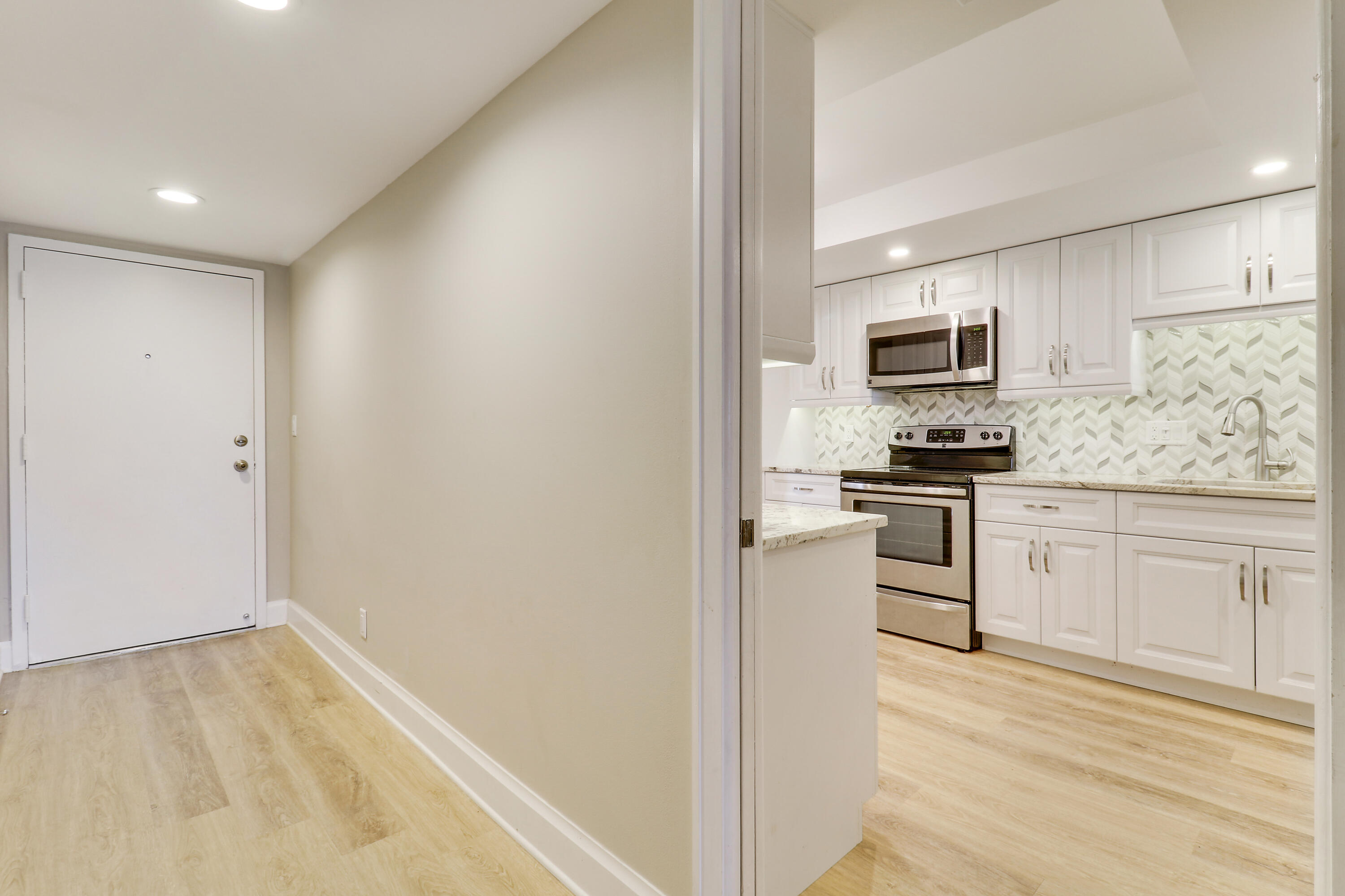 1036 Highway 1, Unit 321 North Palm Beach, FL 33408 - Photo 6 of 40 a kitchen with white cabinets and stainless steel appliances