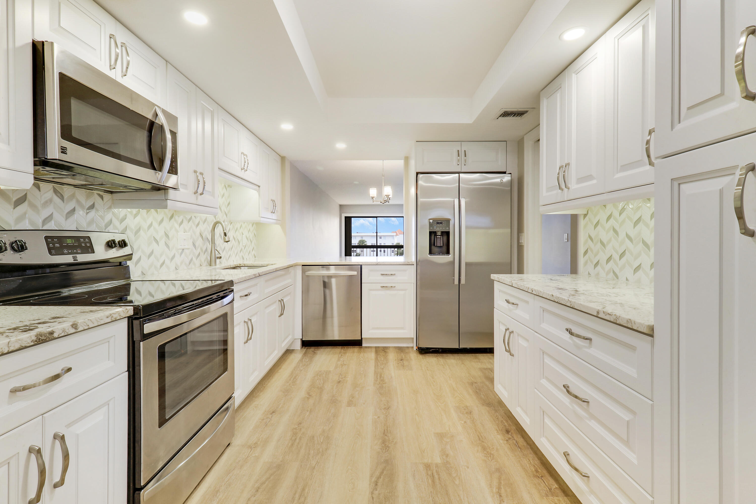 1036 Highway 1, Unit 321 North Palm Beach, FL 33408 - Photo 9 of 40 a kitchen with stainless steel appliances granite countertop a stove a sink and a refrigerator