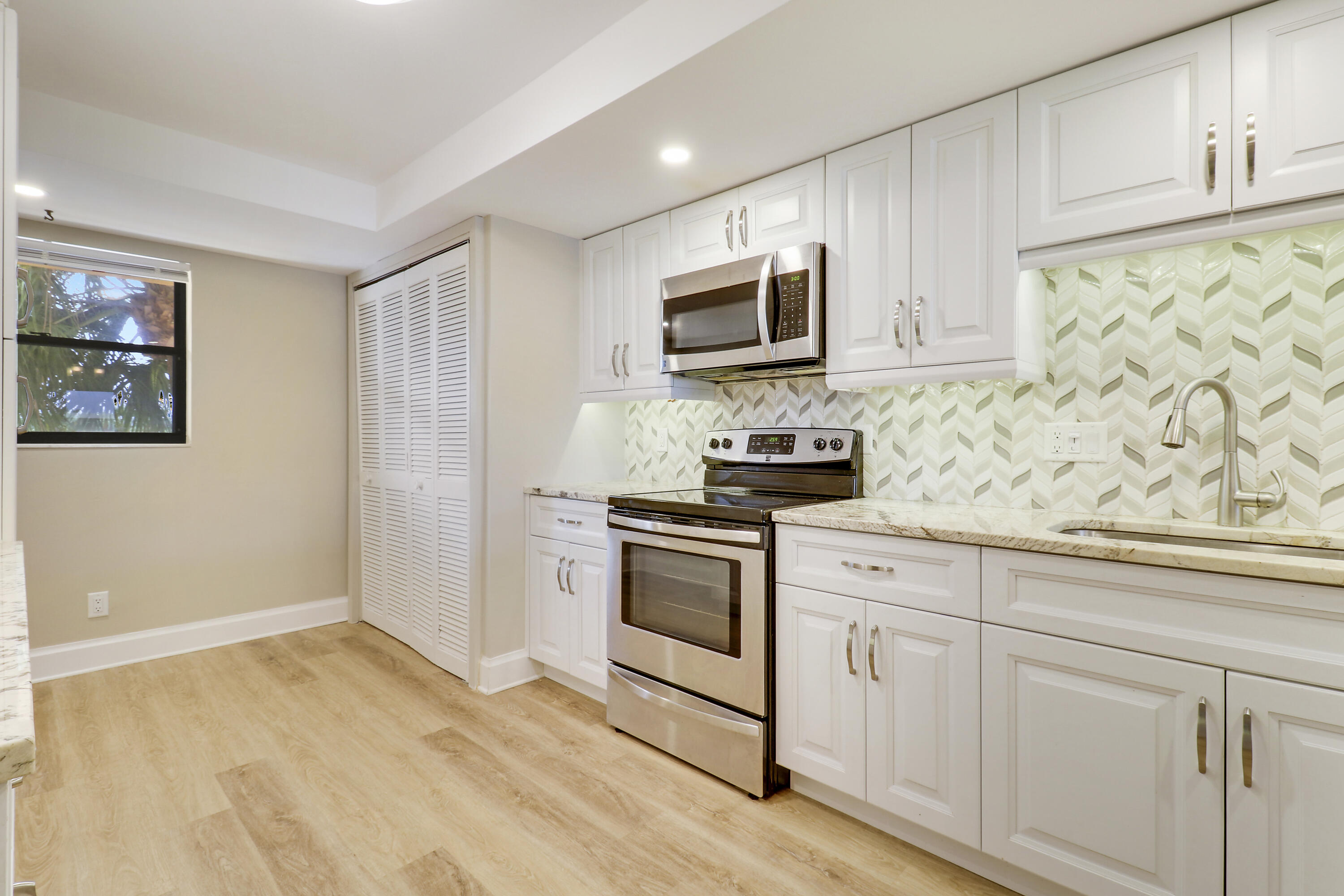 1036 Highway 1, Unit 321 North Palm Beach, FL 33408 - Photo 10 of 40 a kitchen with white cabinets stainless steel appliances and sink