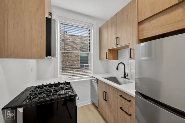 a kitchen with granite countertop a sink stove and cabinets