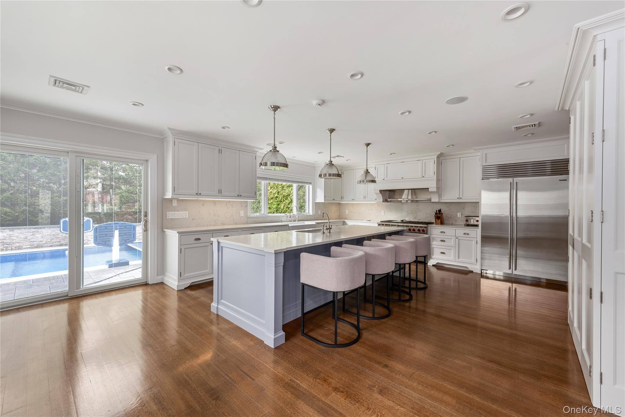 154-96 Riverside Drive Queens, NY 11357 - Photo 8 of 27 a kitchen with stainless steel appliances a dining table chairs stove refrigerator and cabinets