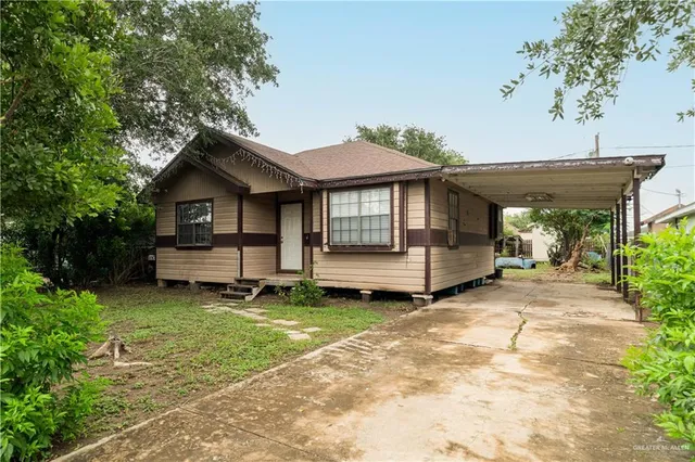 a view of a house with a yard and sitting area