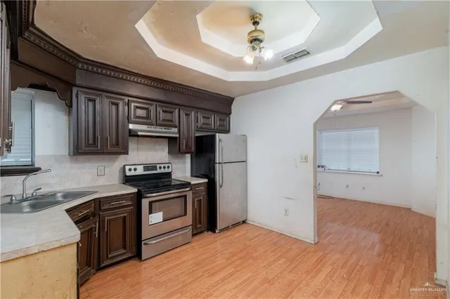 a kitchen with stainless steel appliances granite countertop a sink stove and refrigerator