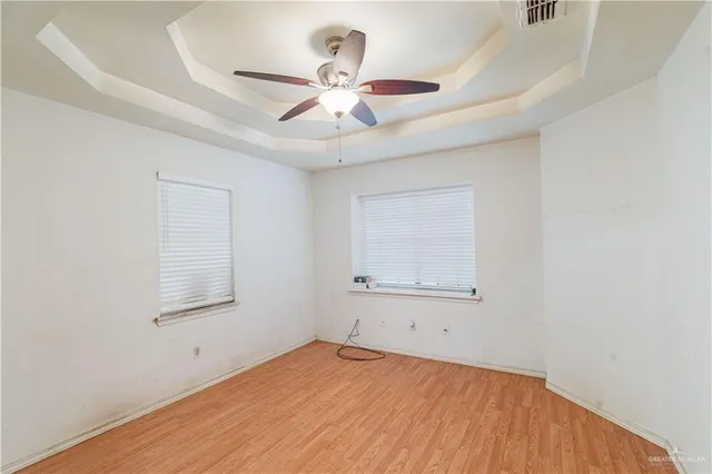 an empty room with a window and a ceiling fan