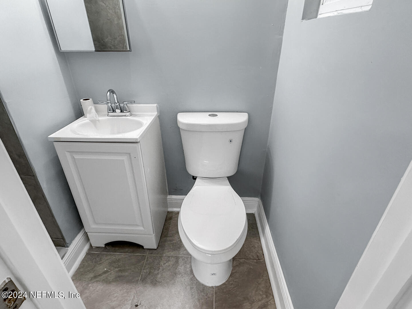 5142 Moncrief Road Jacksonville, FL 32209 - Photo 11 of 27 a white toilet sitting next to a white sink and a mirror