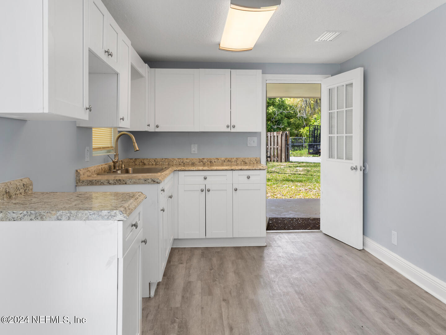 5142 Moncrief Road Jacksonville, FL 32209 - Photo 5 of 27 a kitchen with a sink a window and cabinets