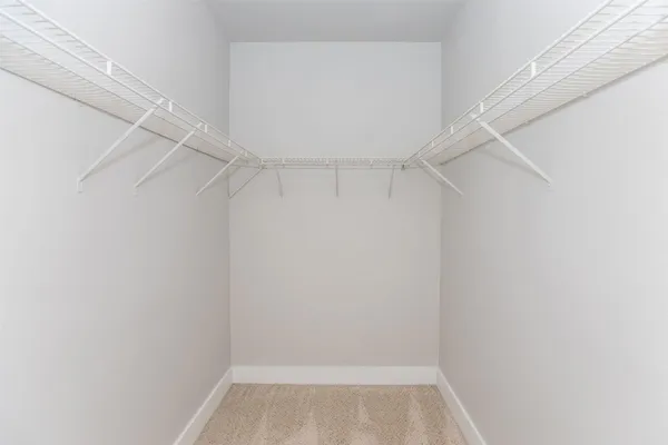 a view of an empty room and chandelier fan