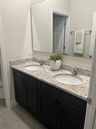 a bathroom with a granite countertop sink and a mirror