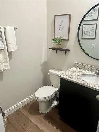 a bathroom with a granite countertop toilet sink and mirror
