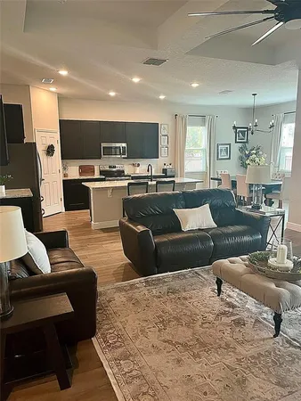 a living room with furniture kitchen view and a flat screen tv