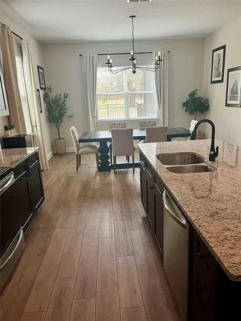 a kitchen with sink a refrigerator and wooden floor