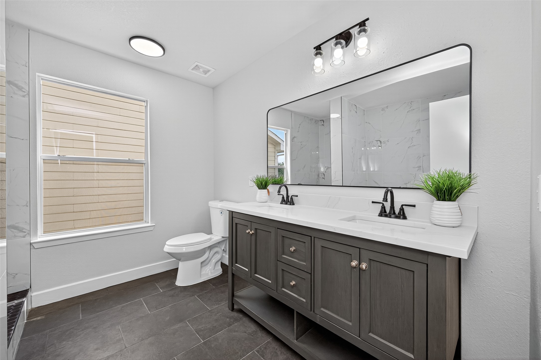 19515 Fletcher Way Drive Houston, TX 77073 - Photo 15 of 27 a spacious bathroom with a double vanity sink a large mirror and a toilet