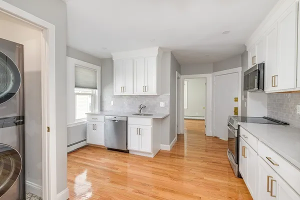 a kitchen with a refrigerator sink and cabinets