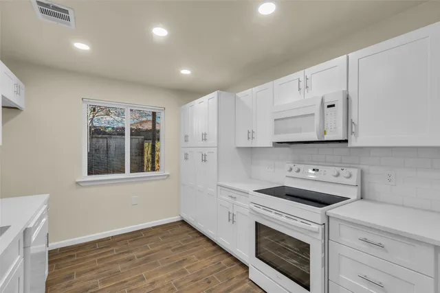 a kitchen with stainless steel appliances white cabinets and a refrigerator