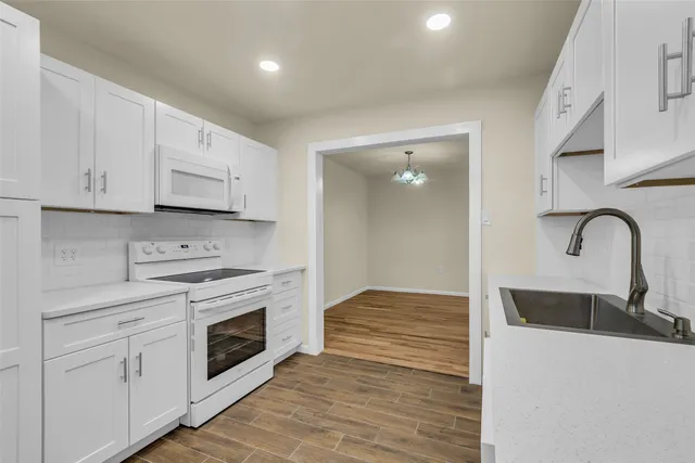 a kitchen with stainless steel appliances granite countertop a stove and white cabinets