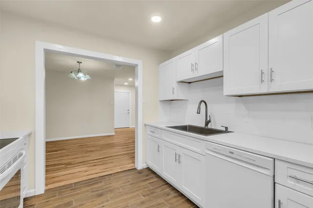 a kitchen with white cabinets stainless steel appliances and sink