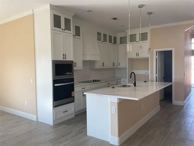 a kitchen with a sink and white cabinets