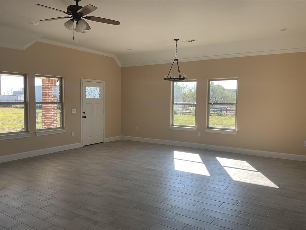 7354 Ne Creek Rice, TX 75155 - Photo 8 of 12 an empty room with wooden floor chandelier and windows