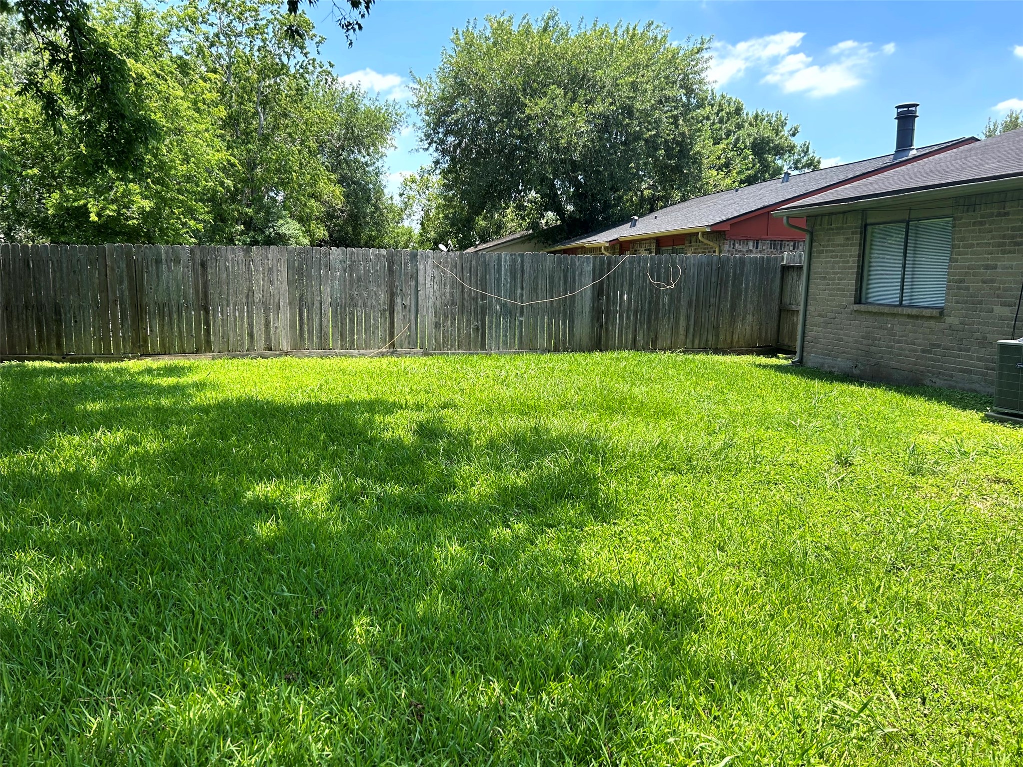 5018 Ridgecreek Drive Houston, TX 77053 - Photo 18 of 18 a view of a backyard with a barbeque and large trees