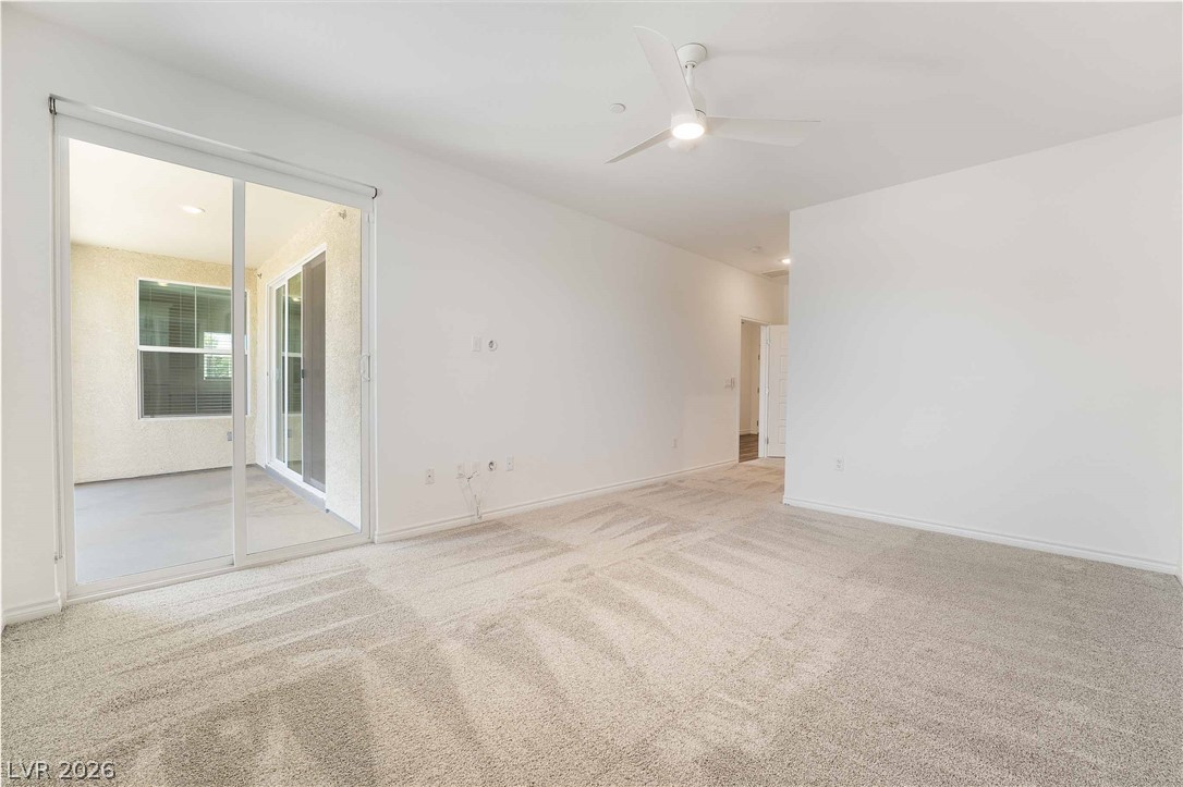 2555 Hampton Road, Unit 10202 Henderson, NV 89052 - Photo 27 of 35 Sliding glass doors open directly to a private covered patio from this carpeted living space.