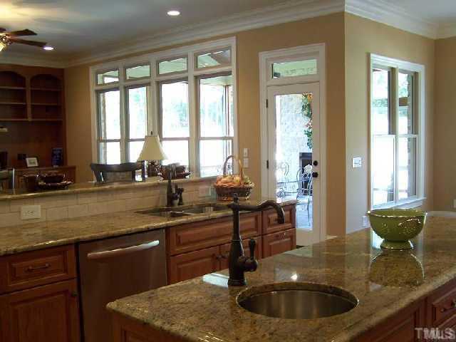 12901 Grovehurst Drive Raleigh, NC 27613 - Photo 3 of 10 a kitchen with a sink and wooden cabinets