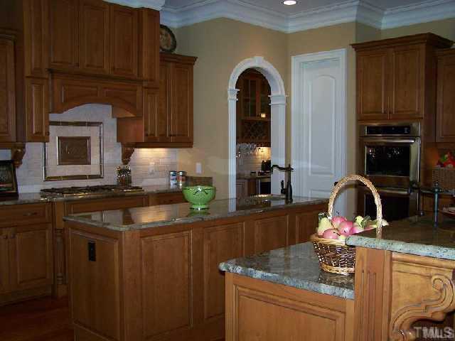 12901 Grovehurst Drive Raleigh, NC 27613 - Photo 4 of 10 a kitchen with stainless steel appliances granite countertop a sink stove and cabinets