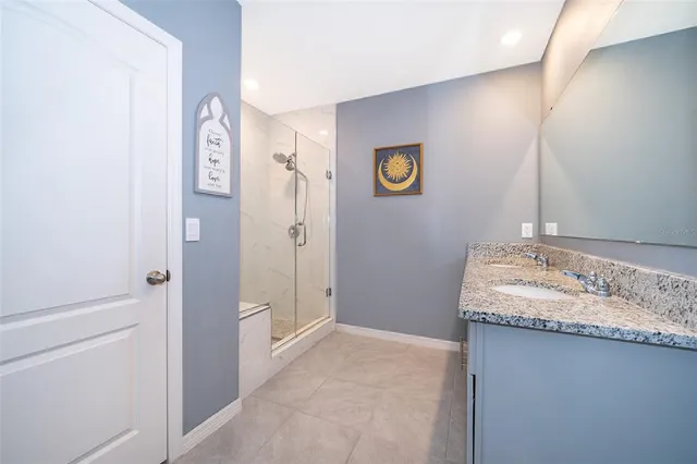 a bathroom with a granite countertop sink and a mirror