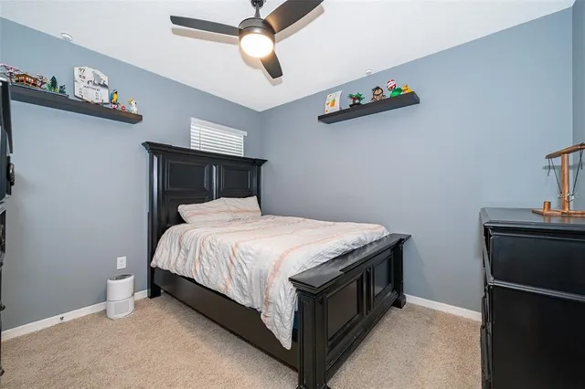 a bed sitting in a bedroom next to a lamp