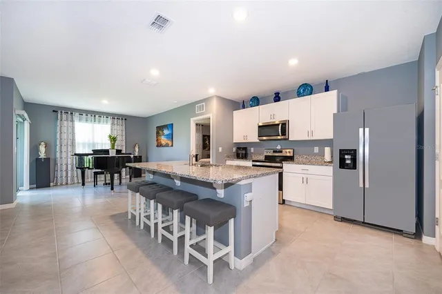 a large kitchen with kitchen island a sink table and chairs