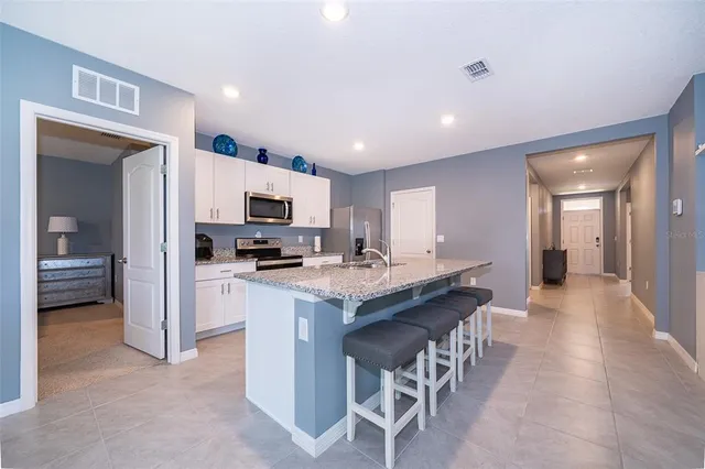 a kitchen with cabinets a sink and chairs in it
