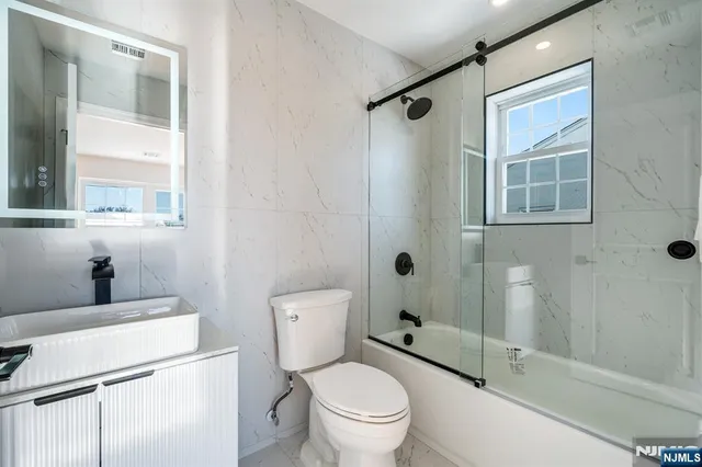 a white toilet sitting next to a bathroom sink