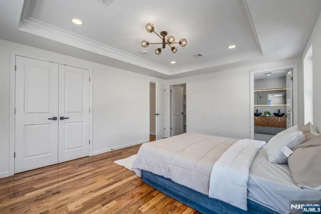a spacious bedroom with a bed and a chandelier