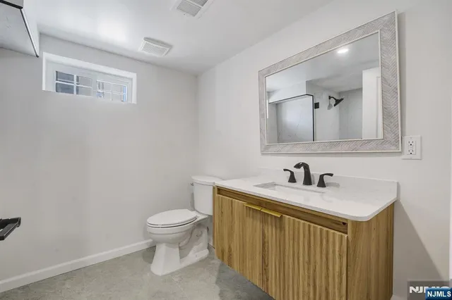 a bathroom with a sink a toilet and mirror