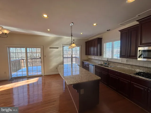 a large kitchen with granite countertop a stove sink and cabinets
