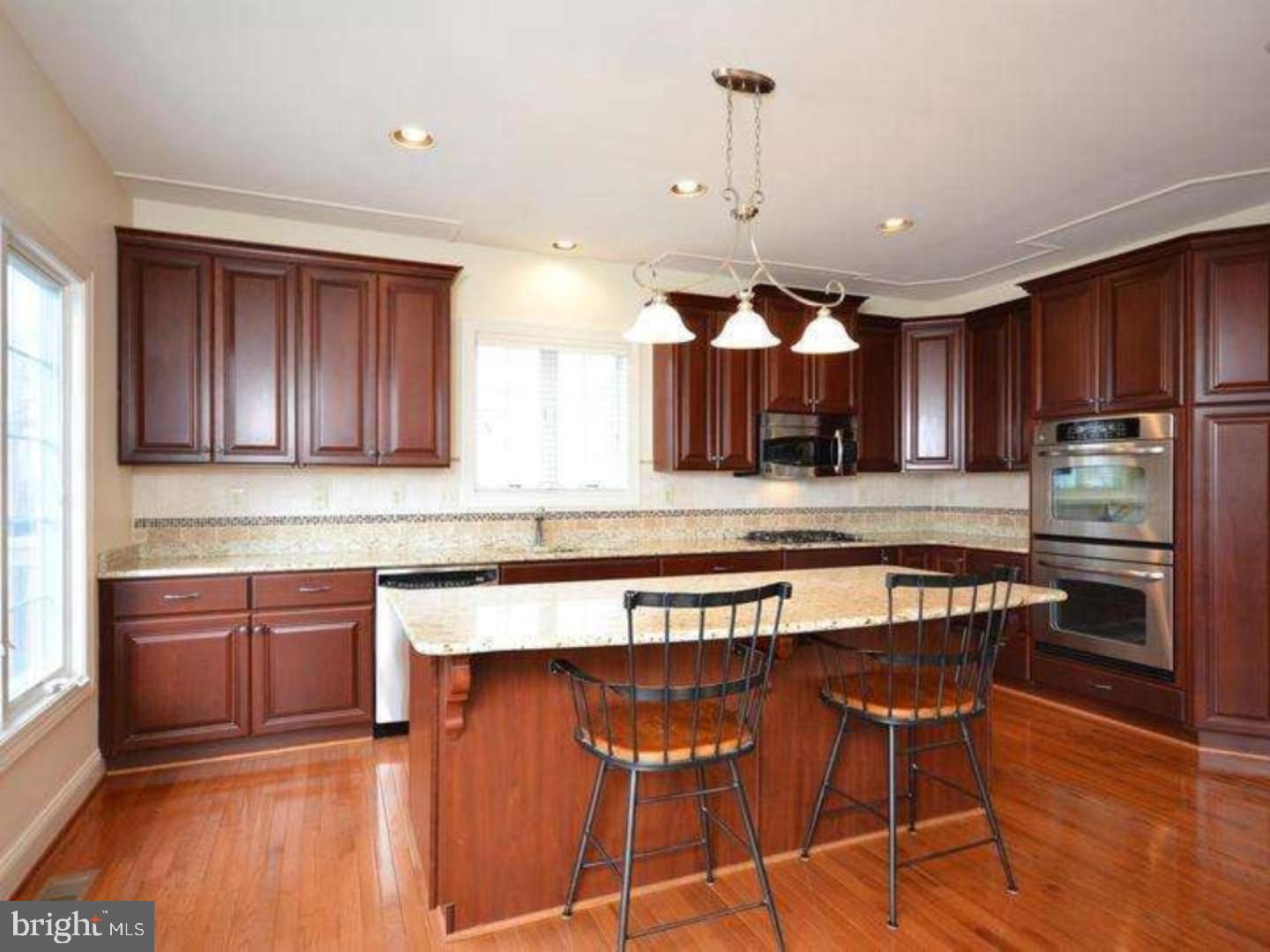 310 Waynebrook Drive Chester Springs, PA 19425 - Photo 8 of 39 a kitchen with stainless steel appliances granite countertop wooden cabinets a stove a sink and a microwave