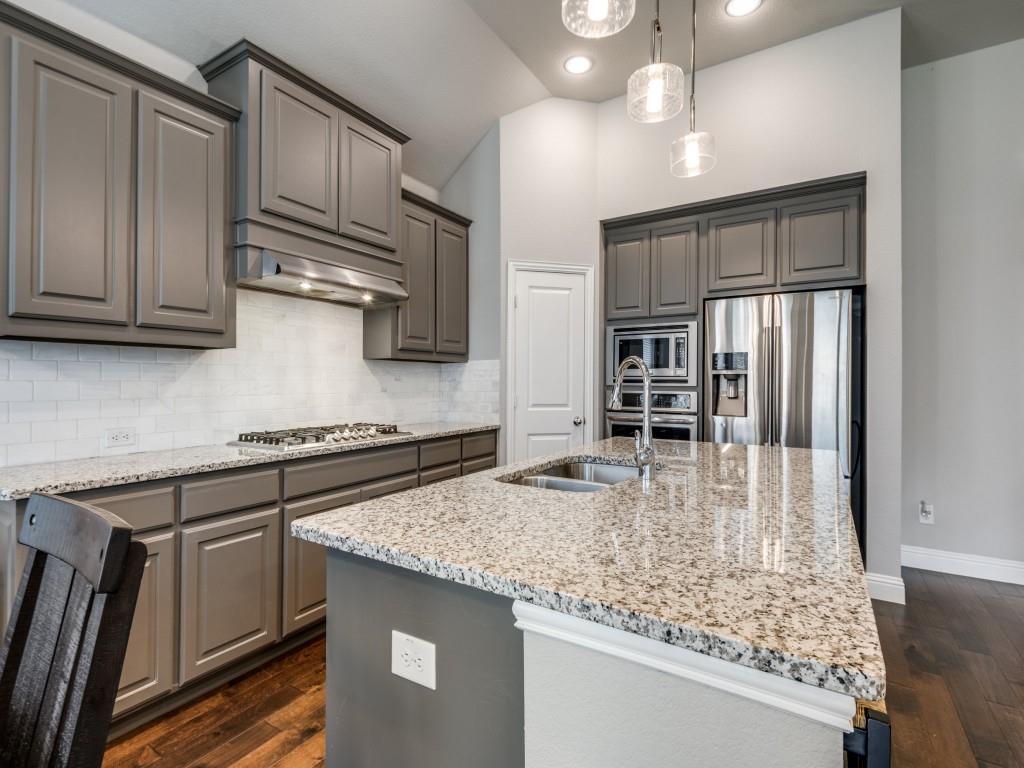 1313 Torrington Lane Forney, TX 75126 - Photo 8 of 40 a kitchen with kitchen island granite countertop a sink cabinets and stainless steel appliances
