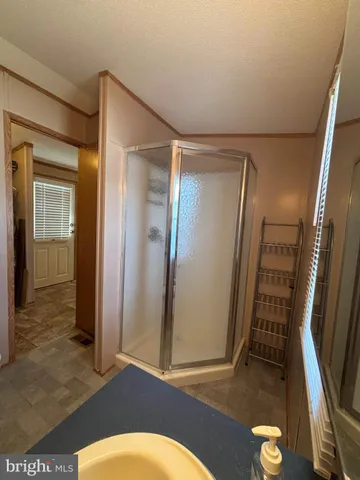 an empty room with wooden floor and fan