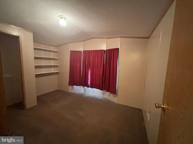 a view of an empty room with a kitchen